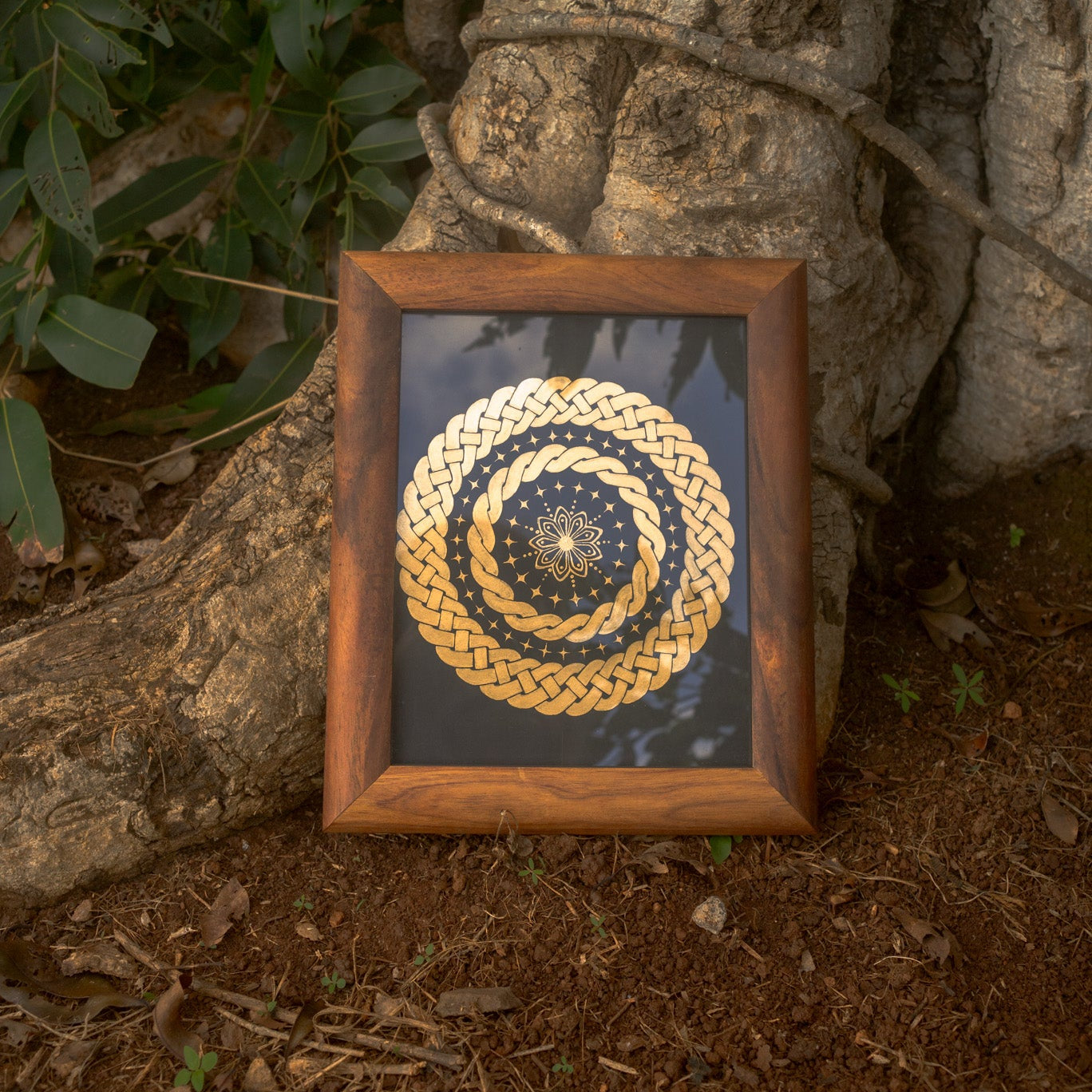Framed artwork with a gold and blue circular design on a natural background