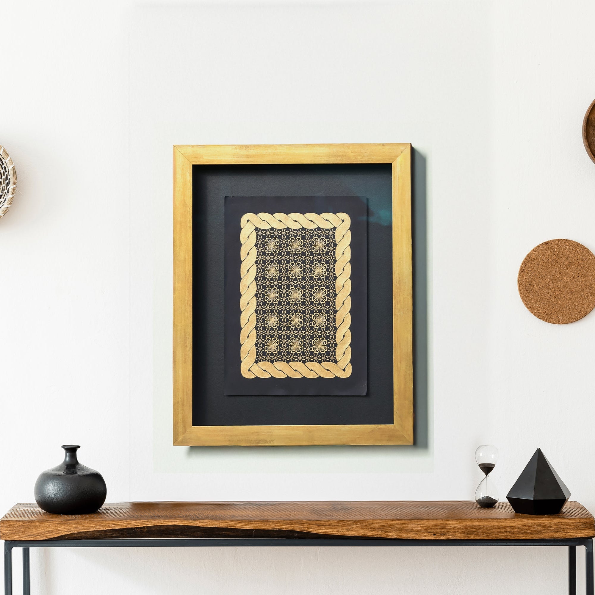 Framed artwork with gold celtic braid border on a wall with decorative items around